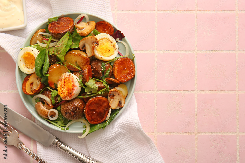 Plate of tasty potato salad with eggs and mushrooms on light pink background, top view