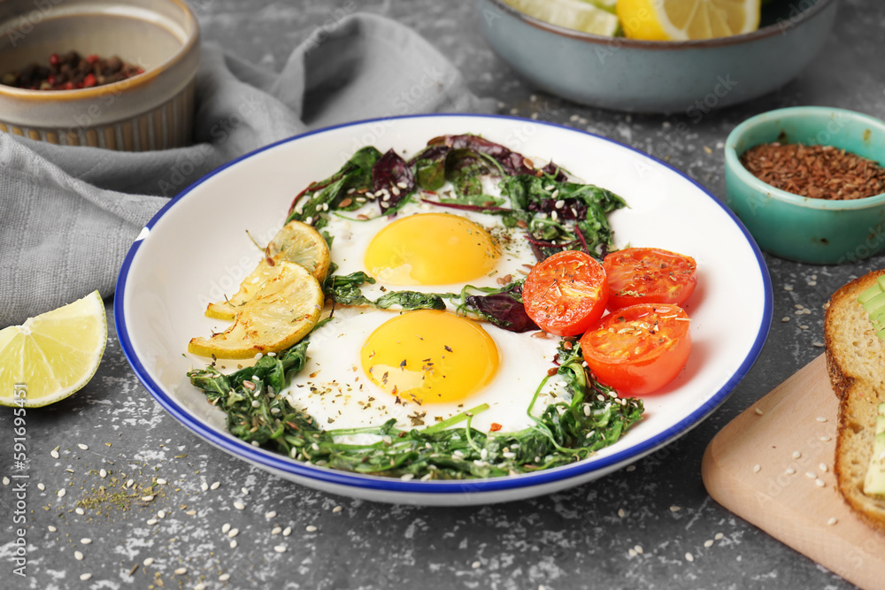 Plate with tasty fried eggs and salad on grey background