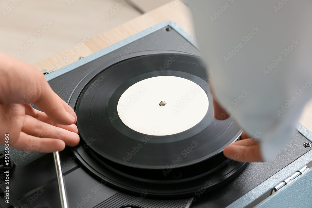 Woman using record player at home, closeup