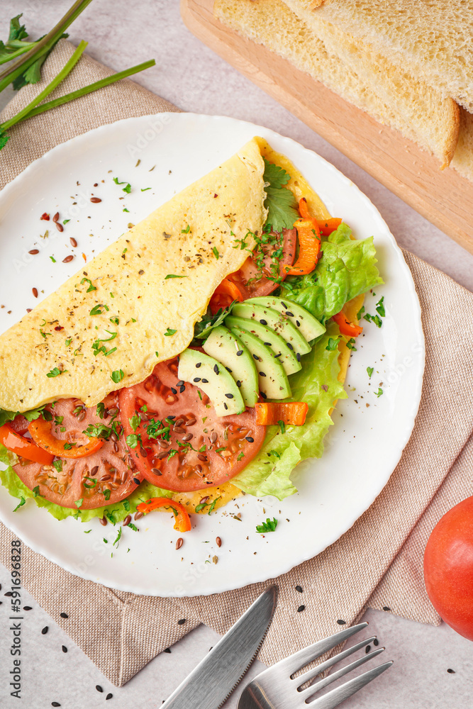 Tasty omelet with vegetables on light table