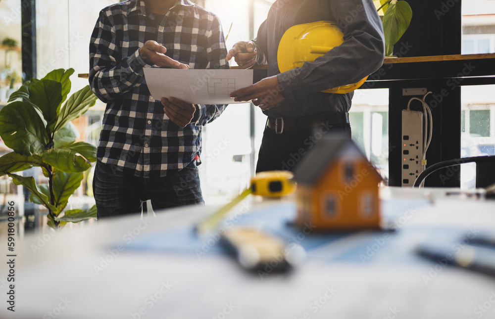 Engineers, architects and contractors discussing on the background of a real estate construction pro