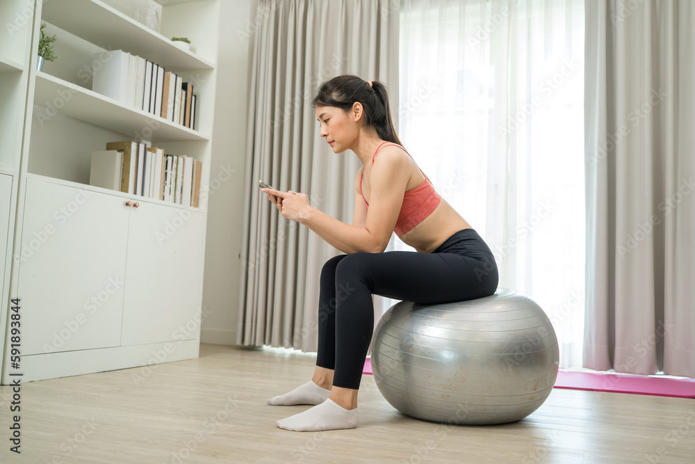 Beautiful woman exercising talking on mobile phone on fitness mat at home,Diet concept,Fitness and h