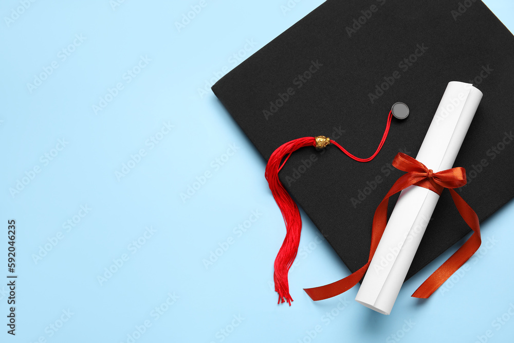 Diploma with red ribbon and graduation hat on blue background