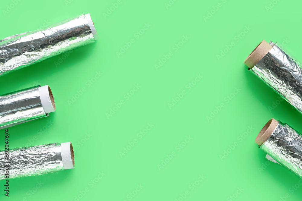 Aluminium foil rolls on green background