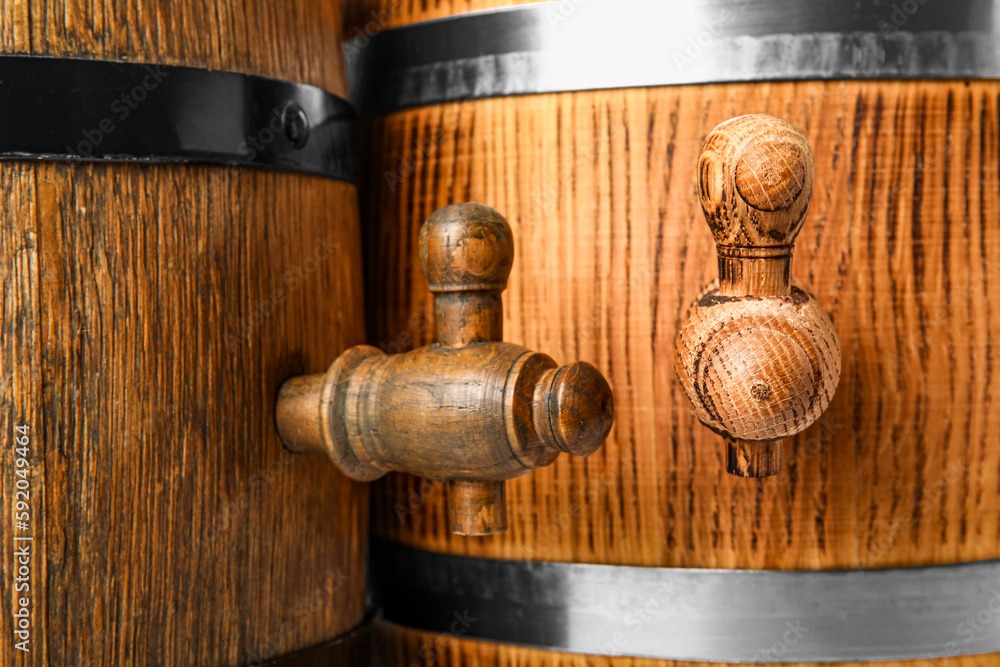 Oak barrels with taps and metal hoops as background, closeup