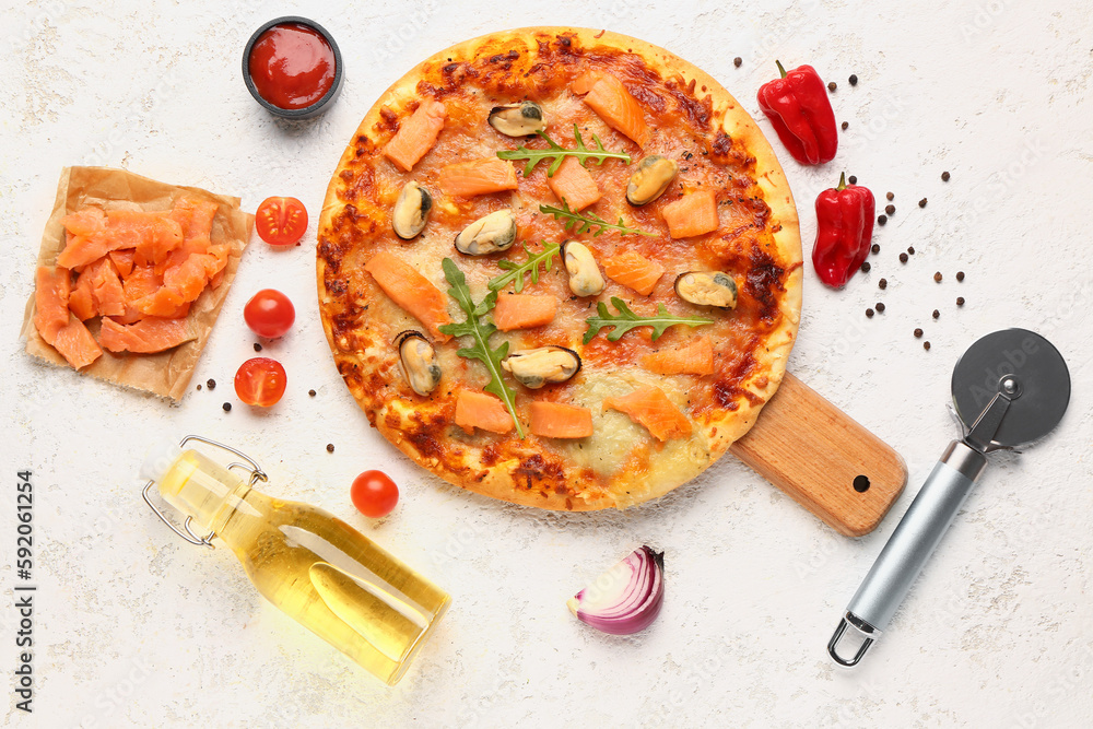 Wooden board with tasty seafood pizza and ingredients on light background