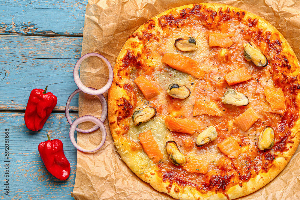 Tasty seafood pizza on blue wooden background