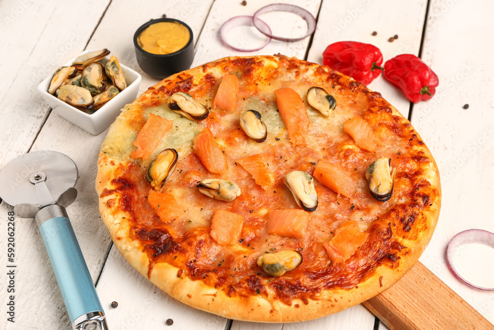 Board with tasty seafood pizza on light wooden background