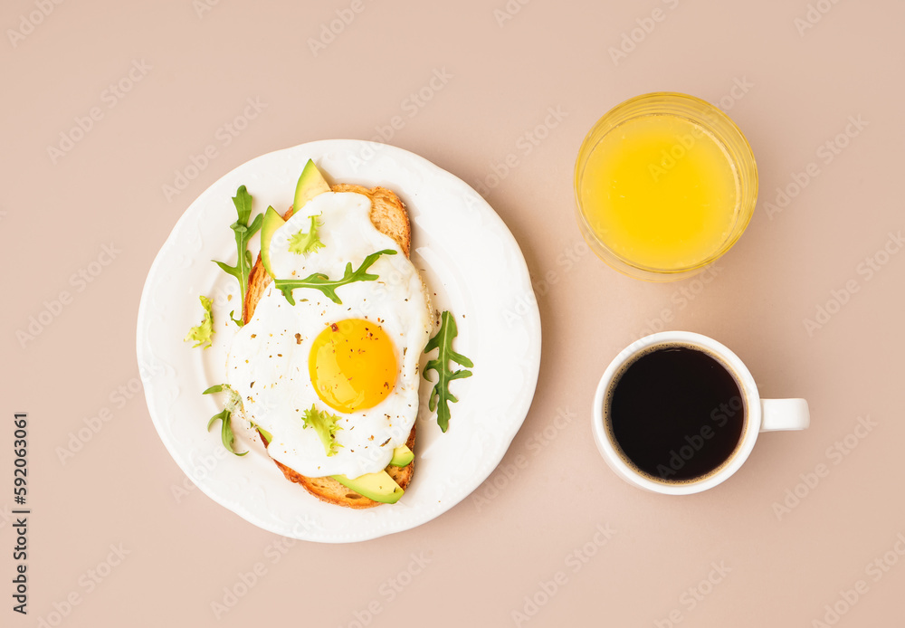 Delicious sandwich with fried egg, avocado and arugula on beige background