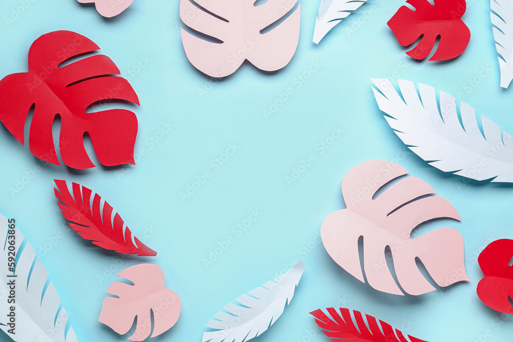 Frame made of paper tropical leaves on blue background