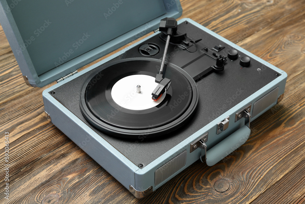 Record player with vinyl disk on wooden background, closeup