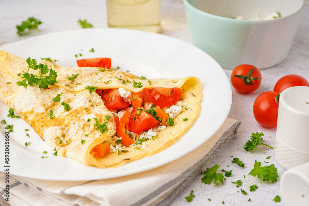 Tasty omelet with tomatoes and parsley on light table