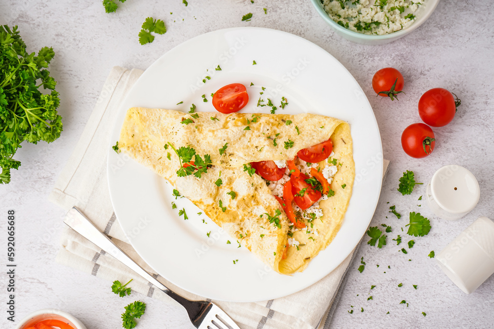 Tasty omelet with tomatoes and parsley on light table