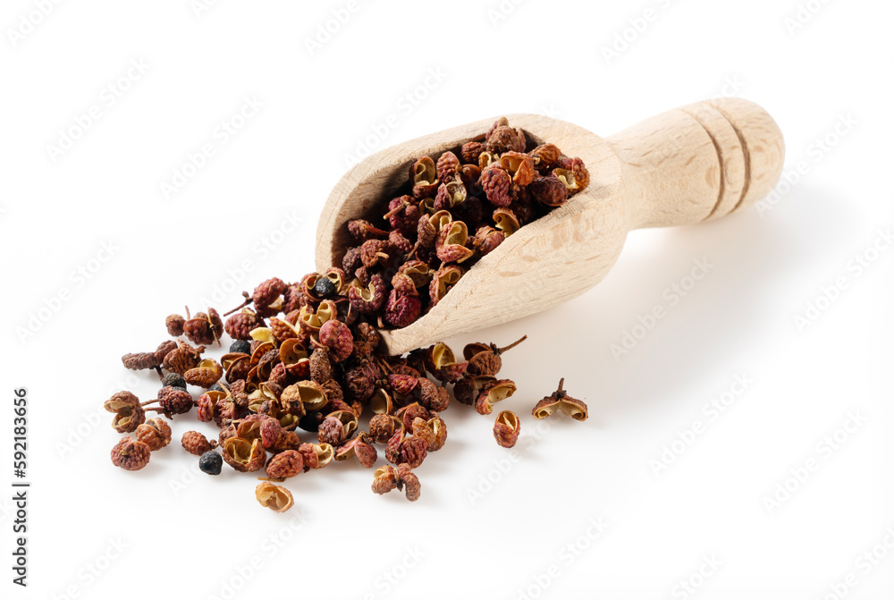 Scoop of sichuan pepper and wood set against a white background.