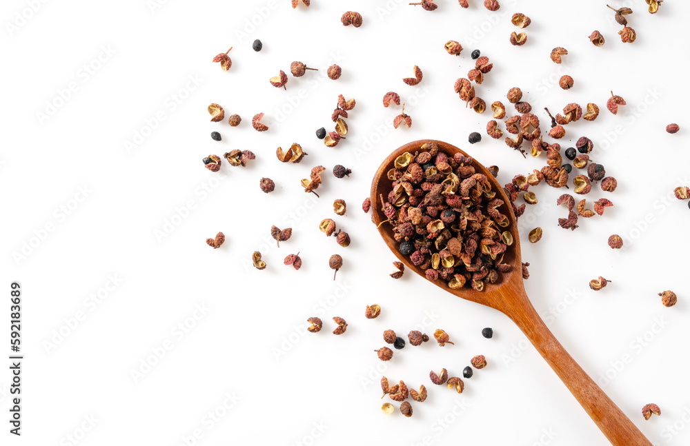 Sichuan pepper and wooden spoon set against a white background.