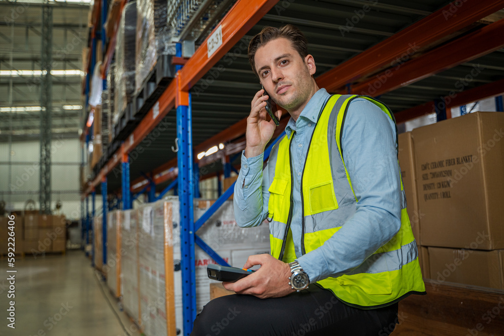 Warehouse worker checking packages on shelf in a large store,Logistics worker storing package boxes.