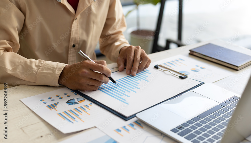 Businessman pointing at financial chart document and statistical market growth analysis. Accounting 