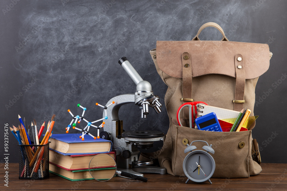 Back to school - books and school backpack on the desk in the auditorium, Education concept.