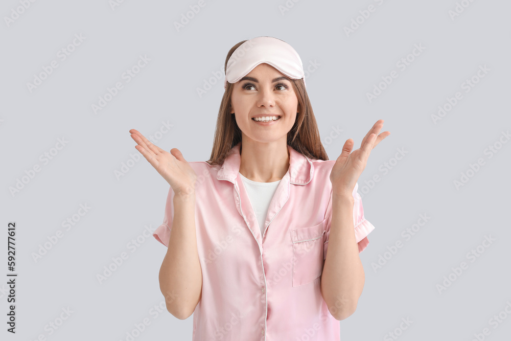 Beautiful woman in pajamas on light background