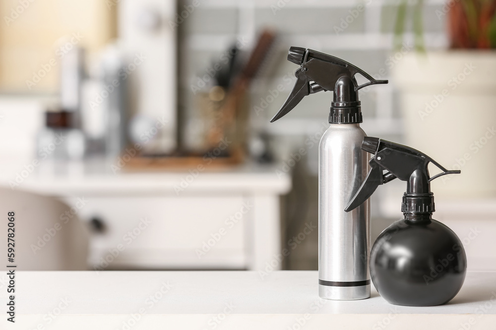 Different hair sprays on table in beauty salon