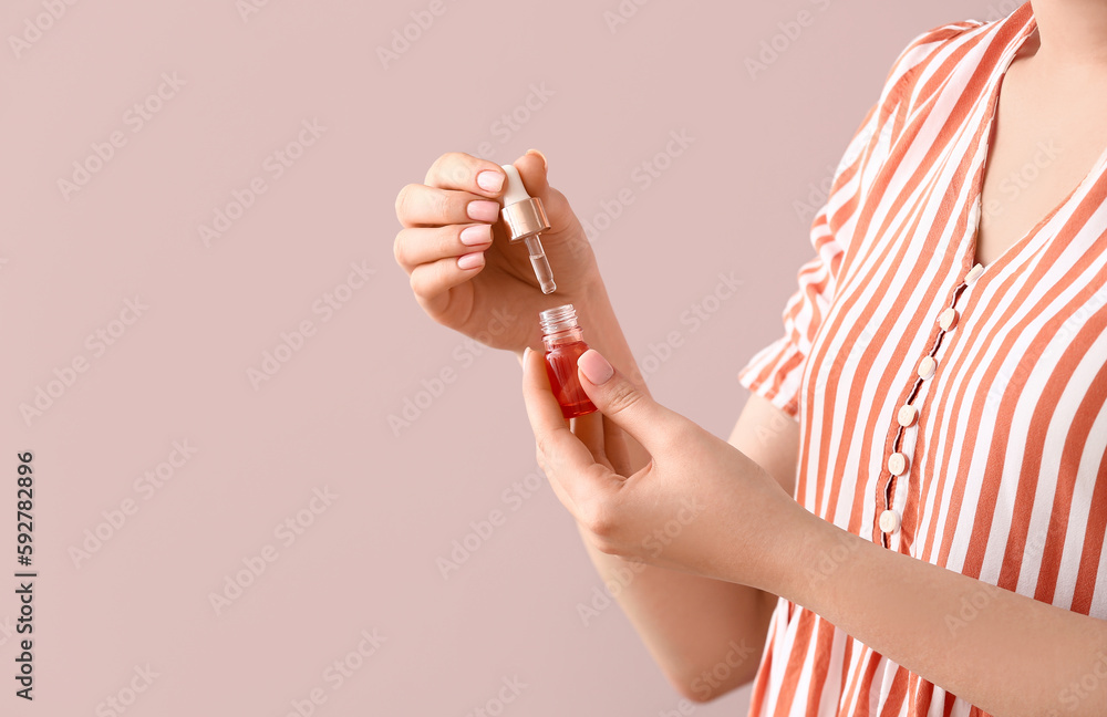 Woman holding bottle of cuticle oil near color wall