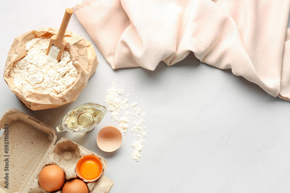 Bag of wheat flour, eggs and oil on white background