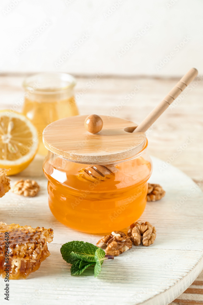 Jar of sweet honey with dipper on table