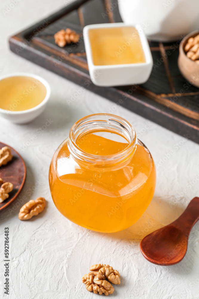 Jar of sweet honey on light background