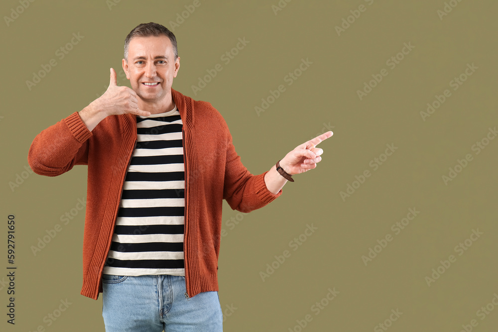 Mature man showing  call me  gesture on green background