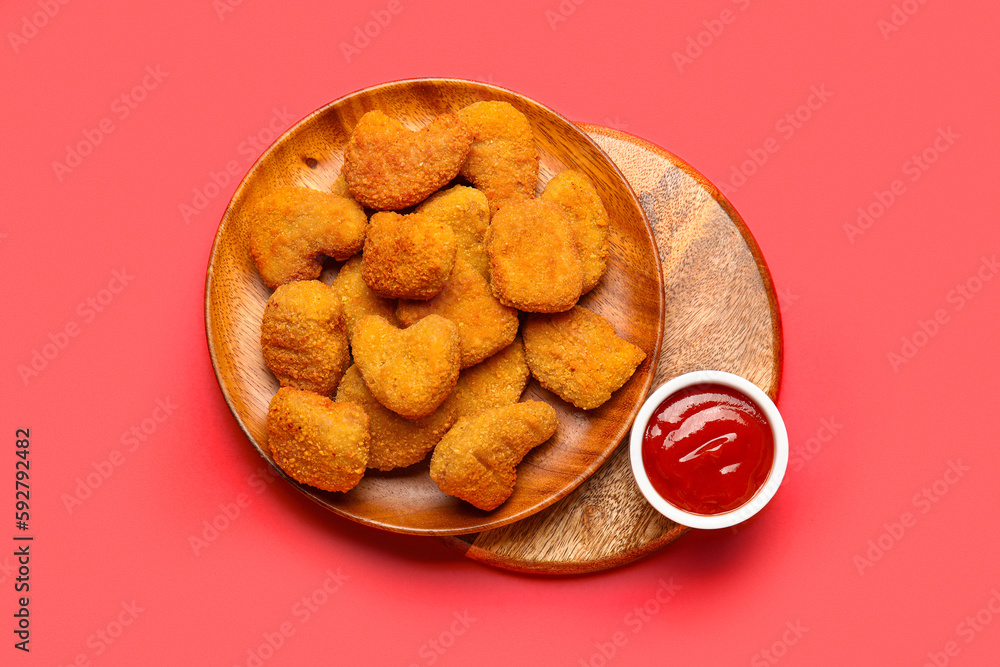 Plates of tasty nuggets and ketchup on red background