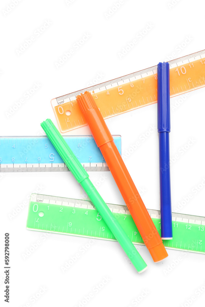 Colorful markers and rulers on white background