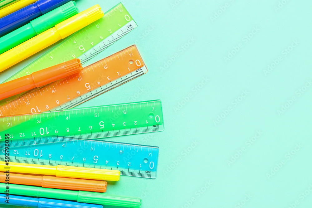 Colorful markers and rulers on blue background