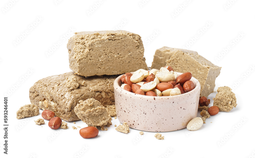 Bowl of peanuts and sweet halva on white background