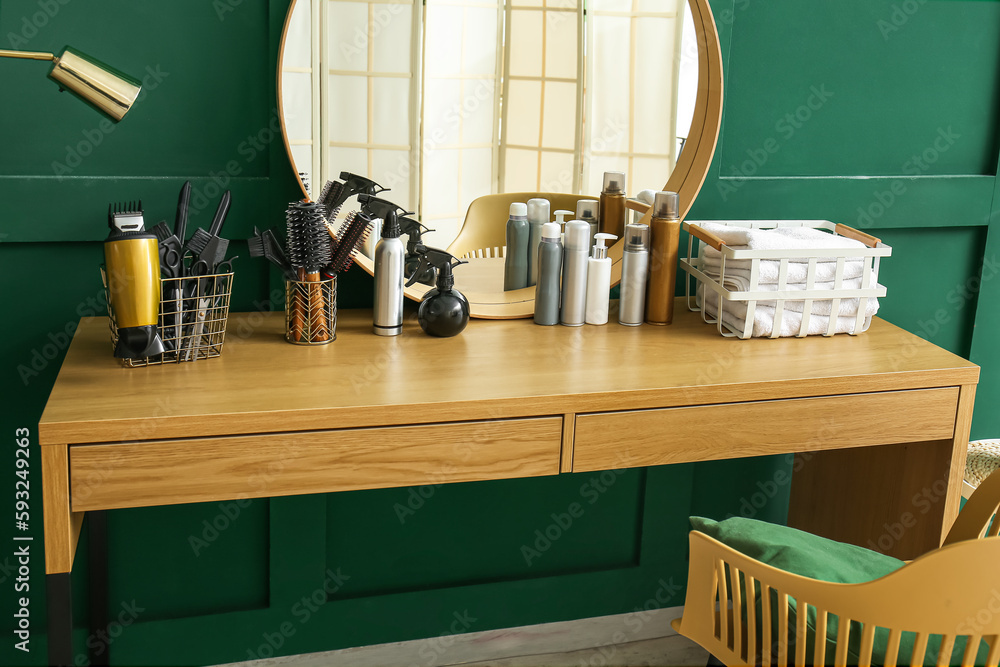 Different hair sprays and accessories on table in beauty salon