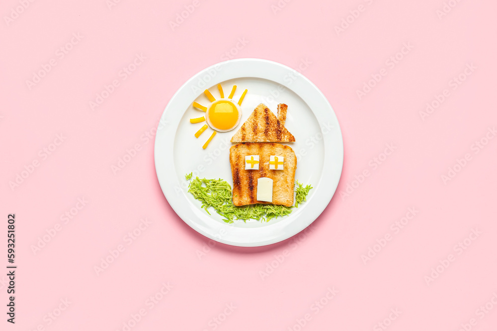 Plate with funny childrens breakfast in shape of house on pink background