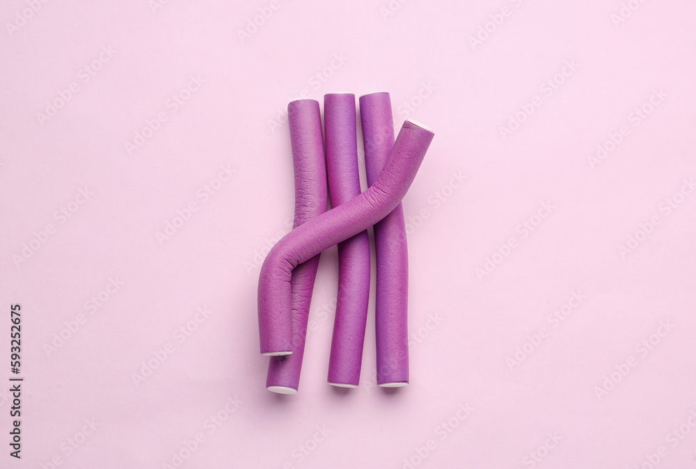 Hair curlers on pink background