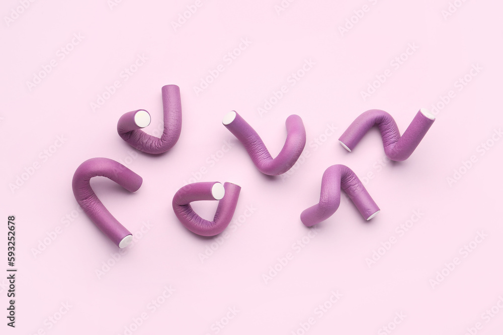 Hair curlers on pink background