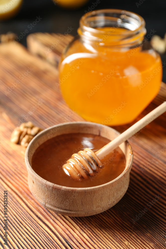 Bowl of sweet honey with dipper on table