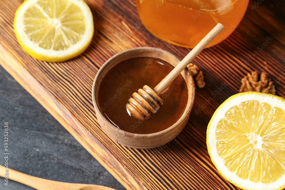 Bowl of sweet honey with lemon on table