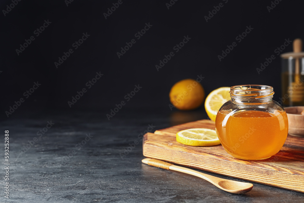 Jar of sweet honey on dark background