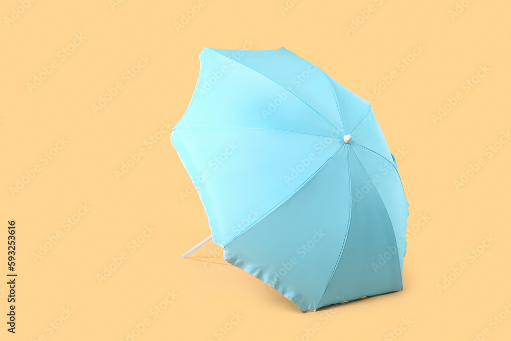 Blue beach umbrella on beige background