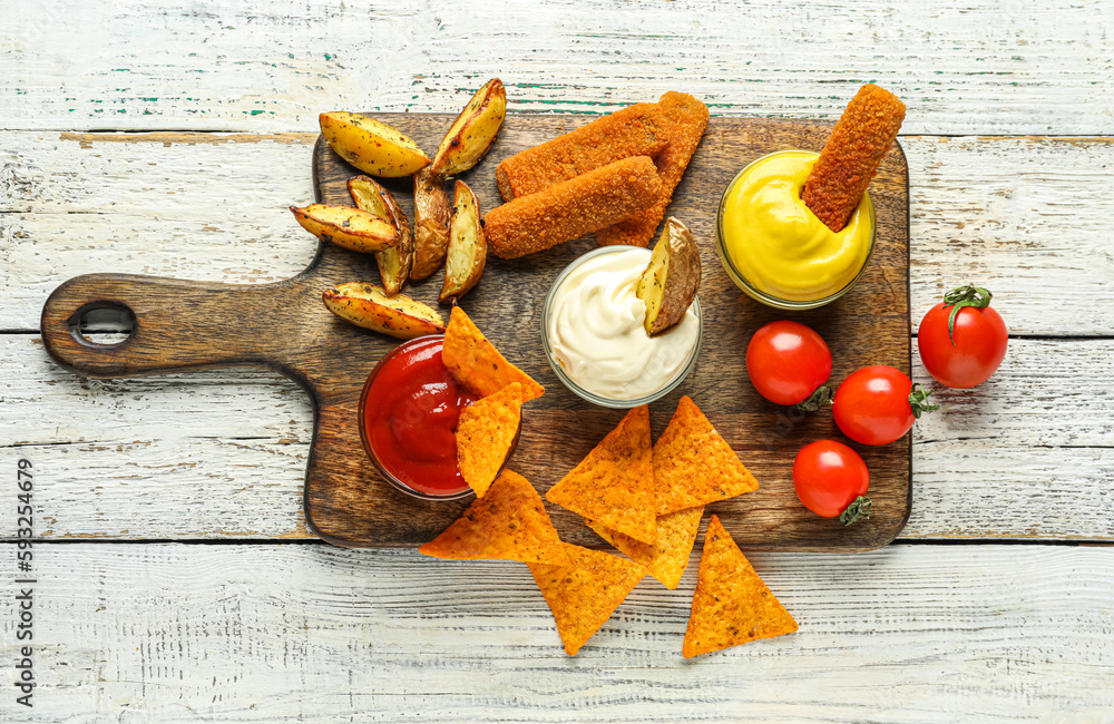 Composition with bowls of different sauces and snacks on white wooden table