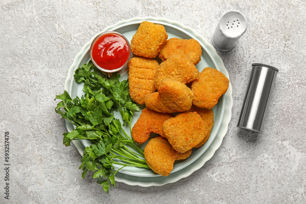 Plates of tasty nuggets with ketchup on light background