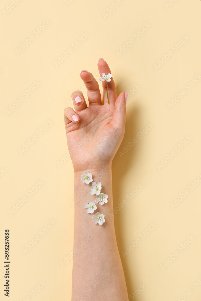 Woman with white flowers on beige background. Hand care concept