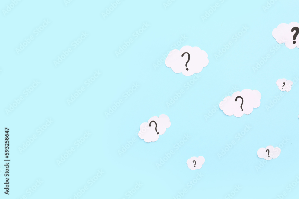 Paper clouds with question marks on blue background