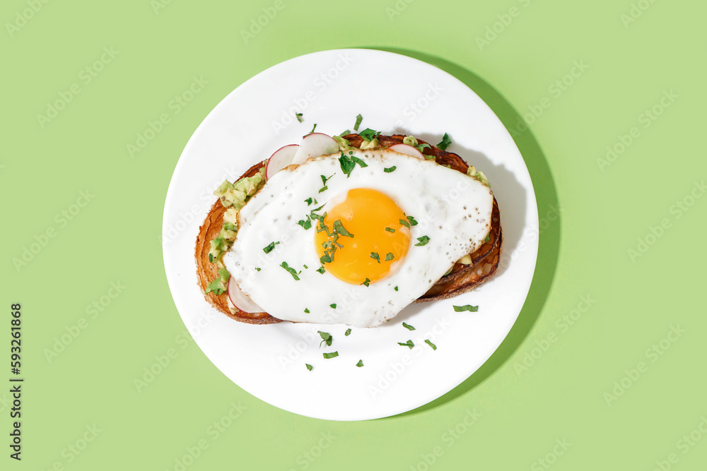 Delicious sandwich with fried egg on green background