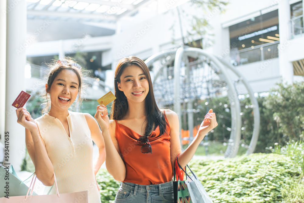 Portrait of two Asian women shopping goods outdoor in department store. 