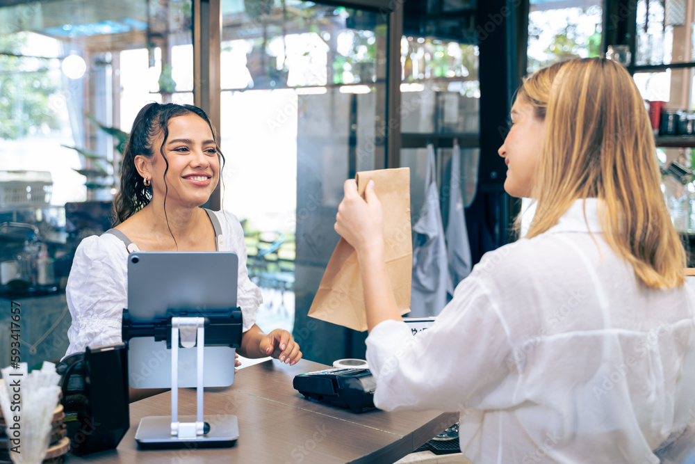 Caucasian attractive women receive coffee from waiter in coffee house. 