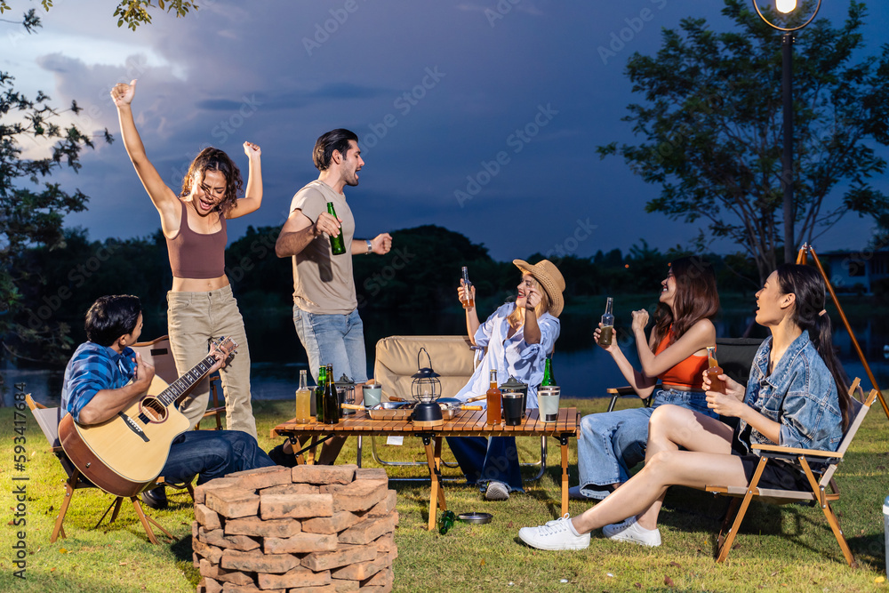 Group of diverse friend having outdoors camping party together in tent. 