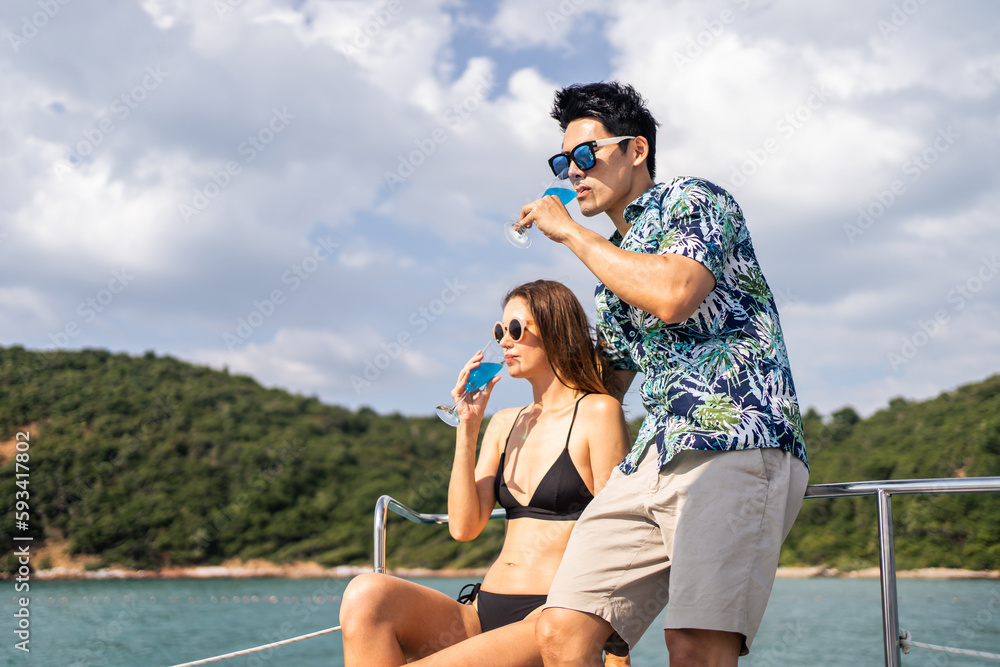 Asian beautiful couple drinking champagne while having party in yacht. 